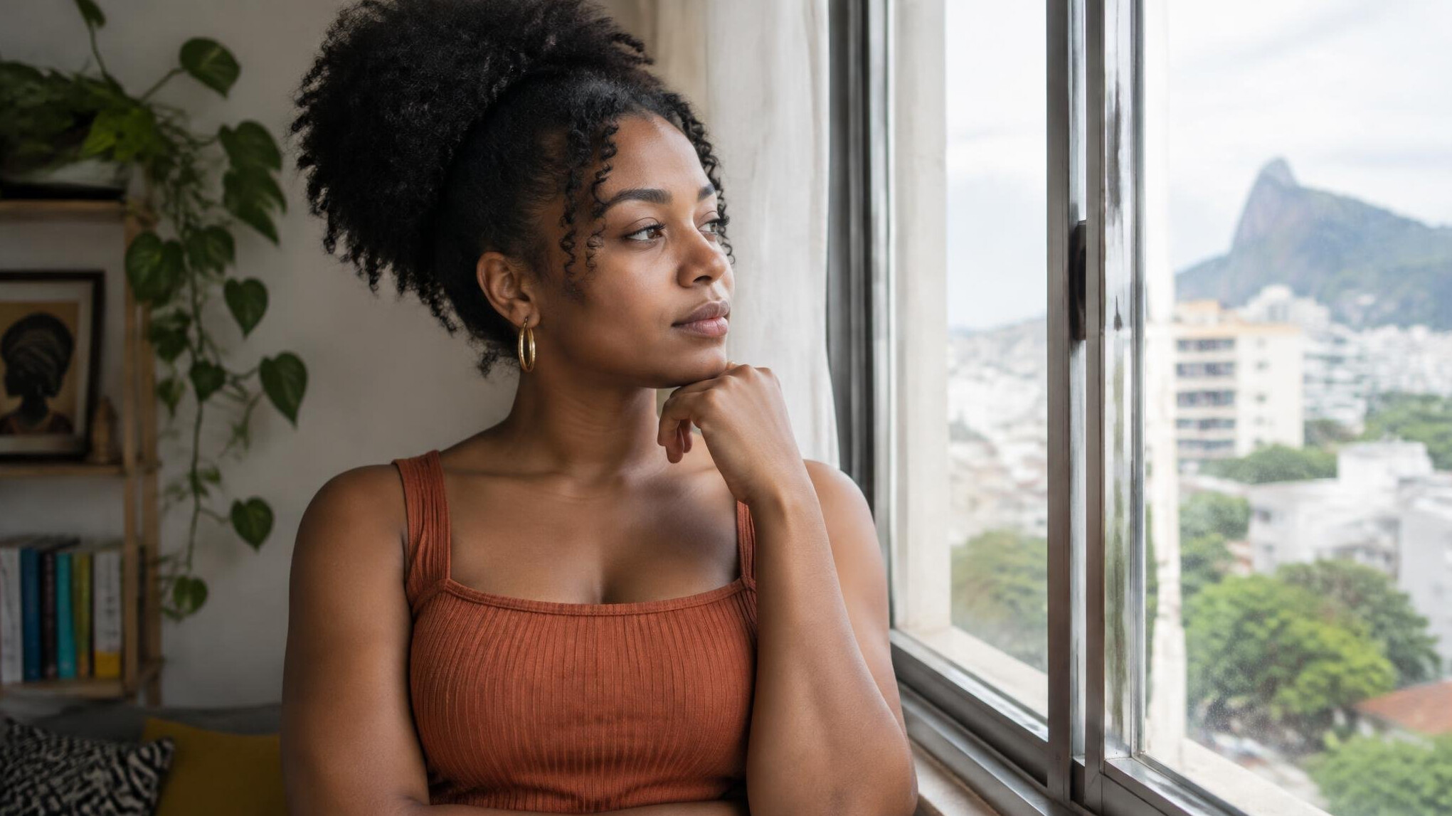 Woman reflecting while looking out a window